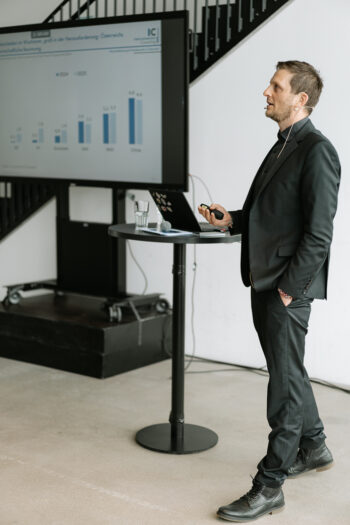 Mann im Anzug spricht auf der Bühne